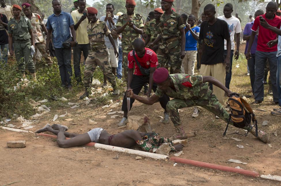 A Central African Army soldier stabs the corpse of a man, who was killed as he was accused of joining the ousted Seleka fighters, in Bangui